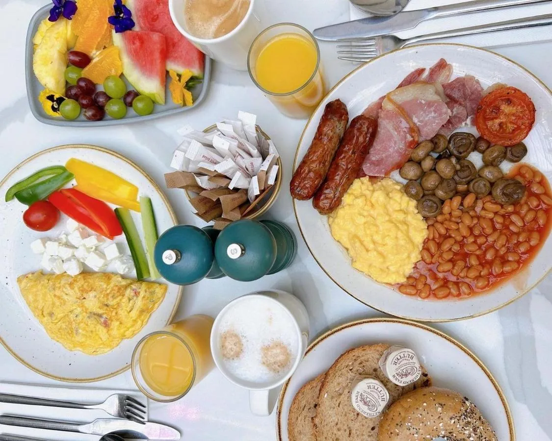 a table with plates of breakfast foods and drinks at The Midland in Manchester