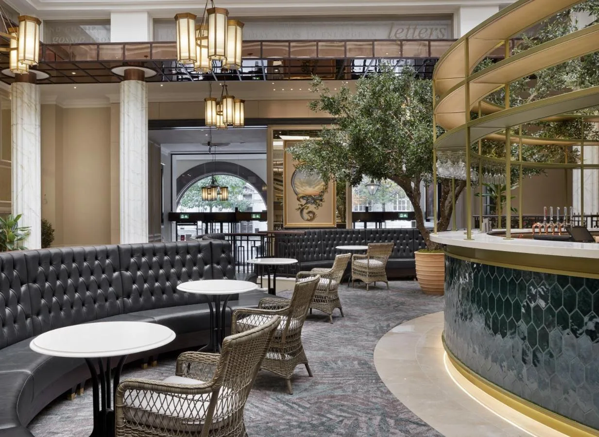 a restaurant with tables and chairs and a bar at The Midland in Manchester