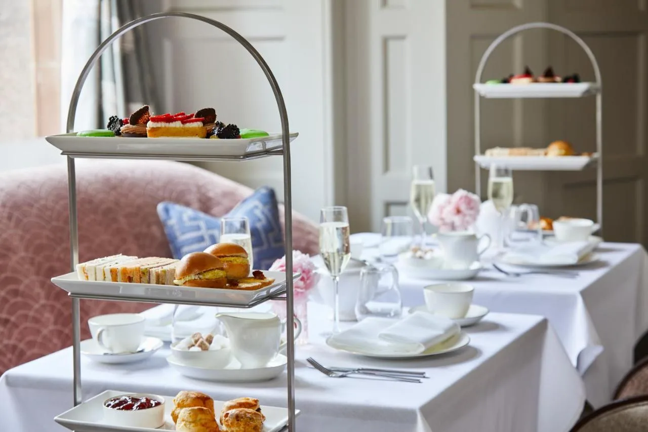 a table with plates of pastries and desserts on plates at The Midland in Manchester