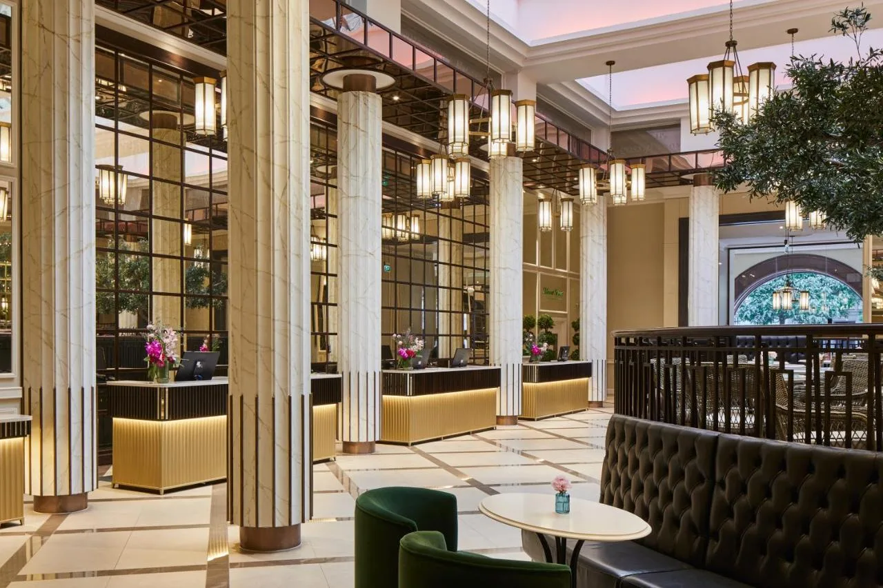 a lobby with columns and tables and chairs at The Midland in Manchester